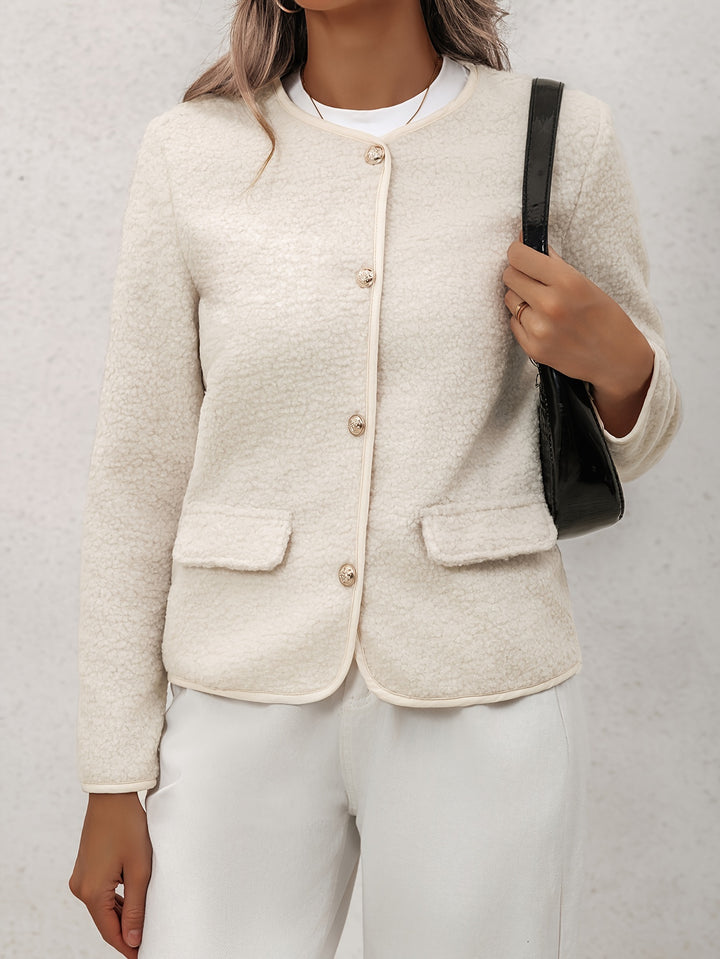 Front view, worn by model, of a cream Eve Chic buttoned long-sleeve jacket with gold buttons and two front pockets