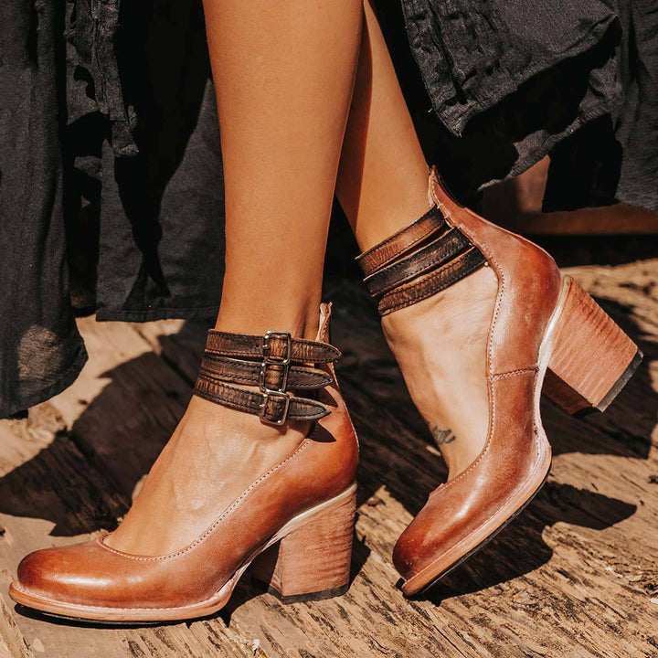 Worn by model, three quarter view of elegant vintage heeled sandals with triple buckled ankle straps
