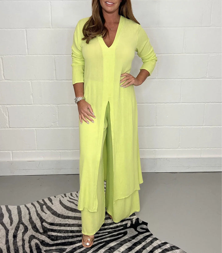 Front view of a model in a jade two-piece wide leg jumpsuit set with a long tunic top and v-neck, hand on hip