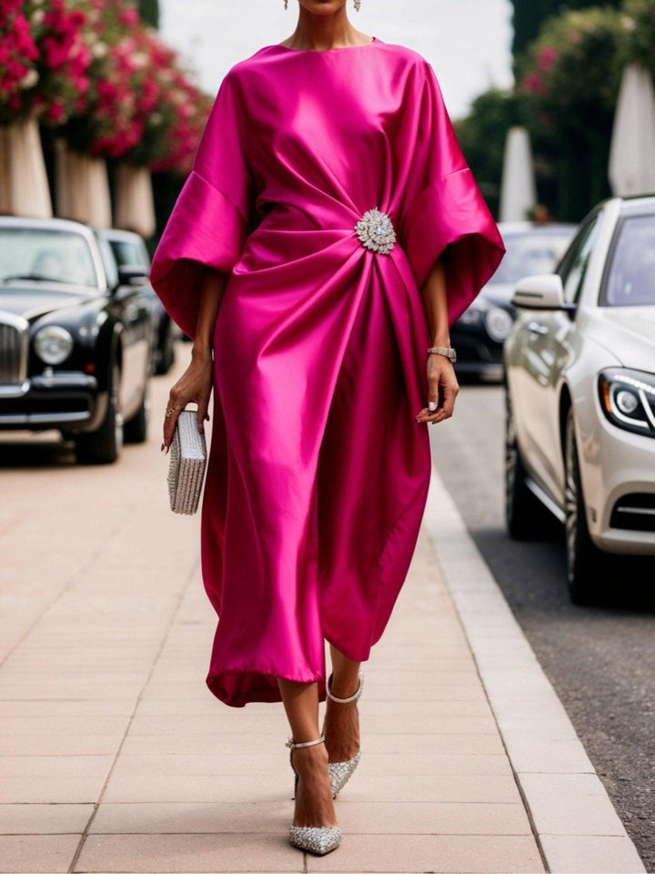 Front view of a model wearing a fuchsia Elena Luxe Shimmer Satin Long Dress with a sparkly brooch and heels