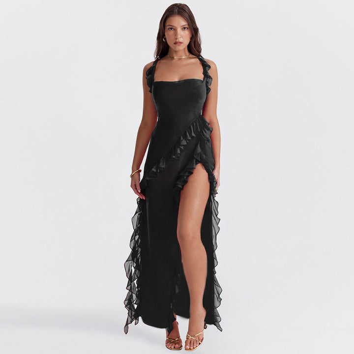 Front view of a model in a black georgette wedding guest dress with ruffled straps and a high side split