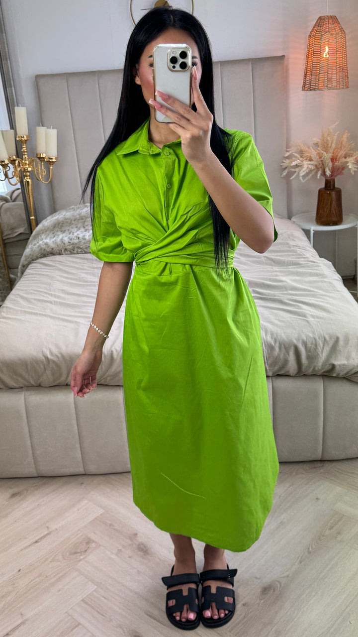 Front view, worn by model, a lime green cross tie belt blouse dress in soft cotton blend with a phone covering her face