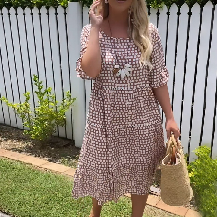 Brown polka dot short sleeve midi dress worn with a straw bag