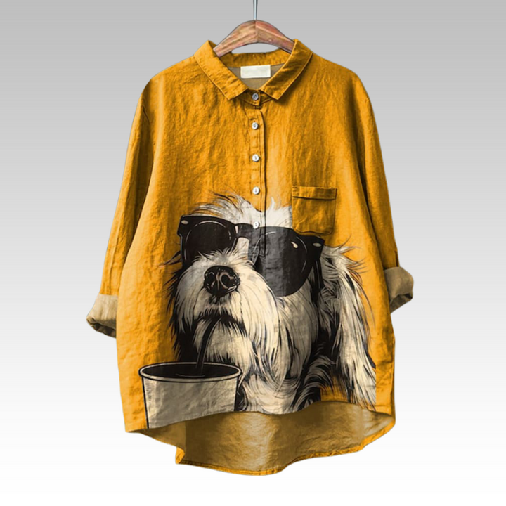 Front view of a classic shirt blouse with a cool dog wearing sunglasses and sipping from a cup print on a mustard yellow top