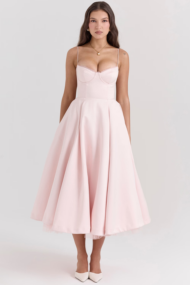 Front view worn by model, a light pink satin corset dress with a structured bodice and full midi skirt