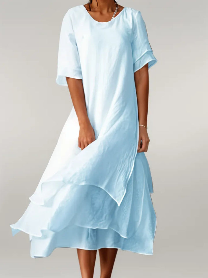Front view of the Oriana Cotton Maxi Dress in light blue worn by a model, showing the layered skirt movement