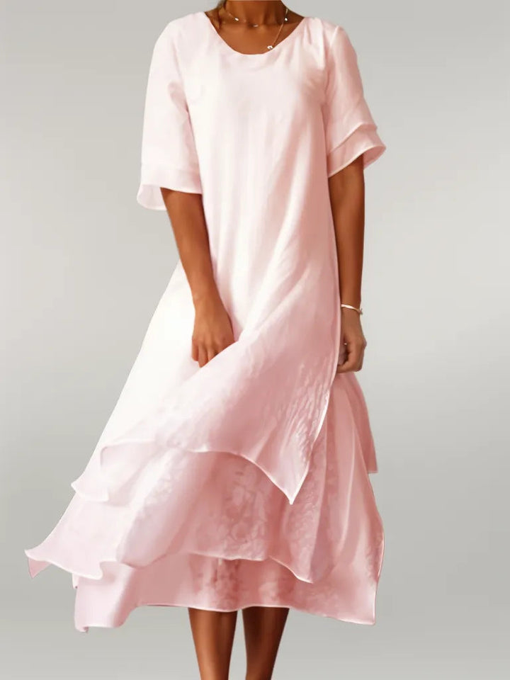 Front view of the Oriana Cotton Maxi Dress in light pink worn by a model, with layered skirt detail