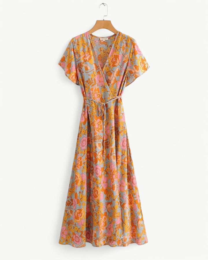 Front view of a floral wrap maxi dress with short sleeves, featuring orange and pink flowers on a light blue background
