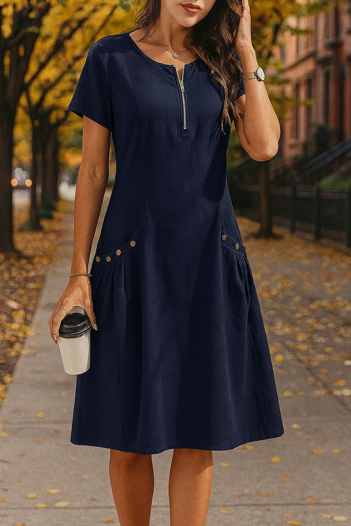 Front view of a model wearing the navy Millie summery dress with zip detail and decorative buttons on pockets