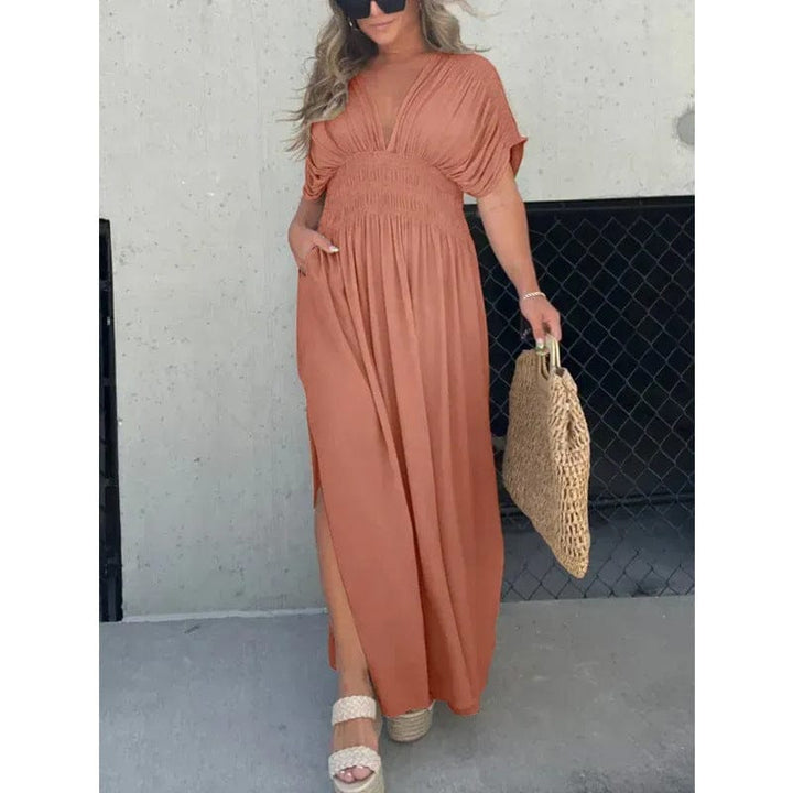 Front view of model wearing a boho style elegant summer maxi dress with side split and pockets, holding a woven bag