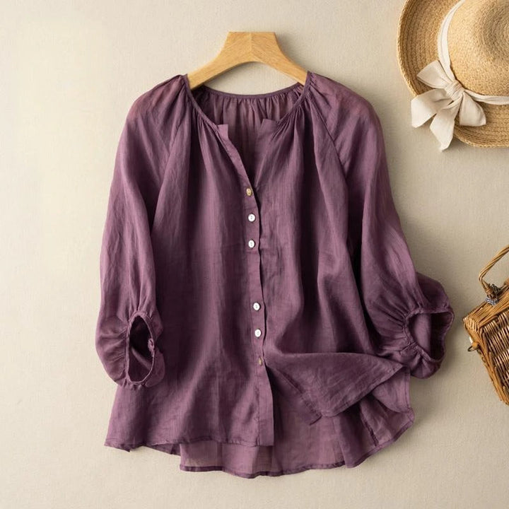 Front view of a purple lightweight linen blouse with elegant ruching on a hanger, showing buttons and sleeve detail