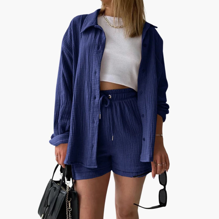 Brianna elegant summer two piece suit, front view worn by model, with black bag and sunglasses, alternate angle