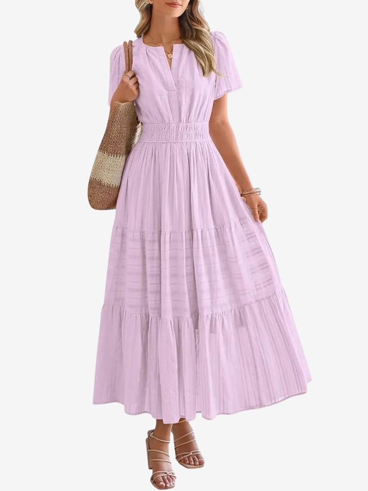 Front view of a model in a lilac tiered maxi dress with cinched waist, V neck, and short puff sleeves
