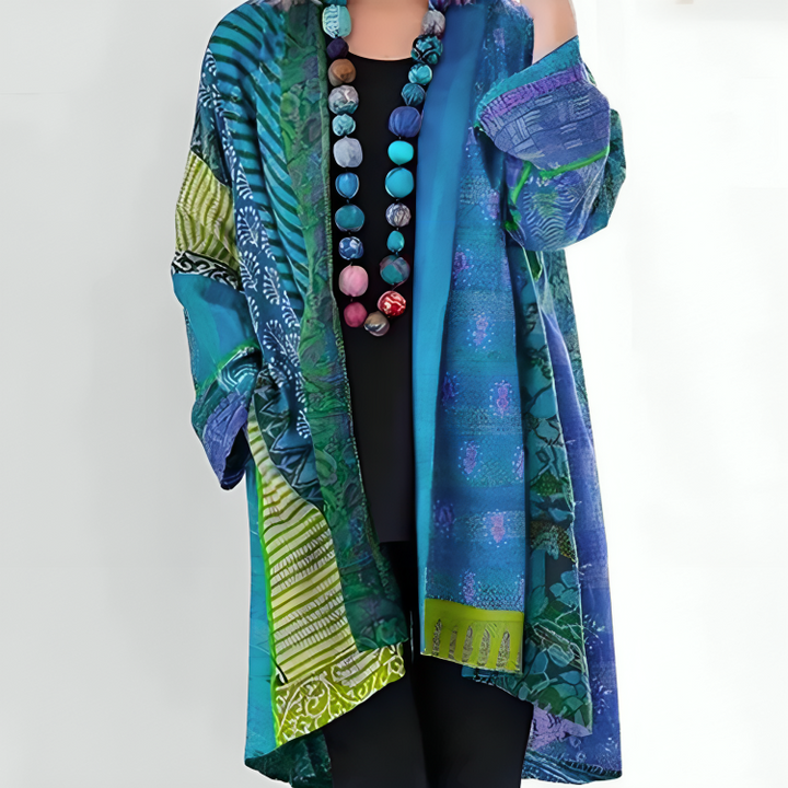 Teal and green patterned Elisa coat worn over a black top