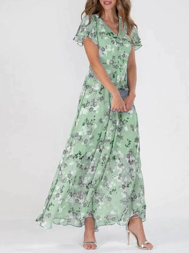 Front view, model in a colourful maxi summer dress, holding a small clutch bag, wearing high heels
