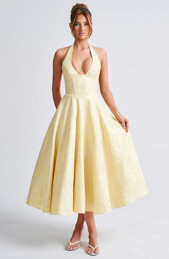 Front view, model wearing a yellow jacquard romantic midi dress with a halter neck and full skirt