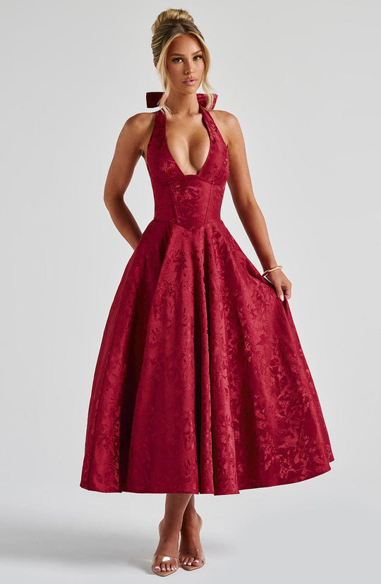 Front view, model wearing a red jacquard romantic midi dress with a halter neck and full skirt