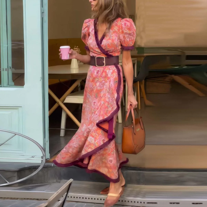 Front view, model wearing a pink maxi dress with short sleeves, a wide brown belt, and holding a coffee cup