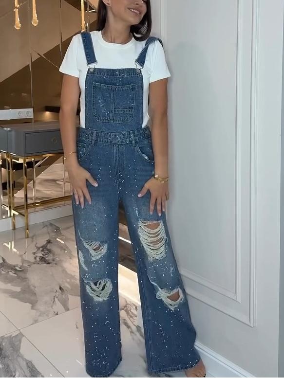 Front view of model wearing ripped denim overalls with white t-shirt and sparkly embellishments