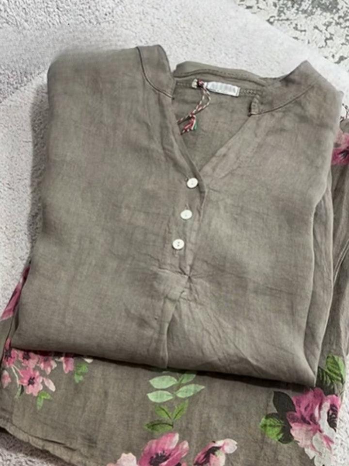 Khaki green cotton linen shirt folded flat with a V neck and white buttons