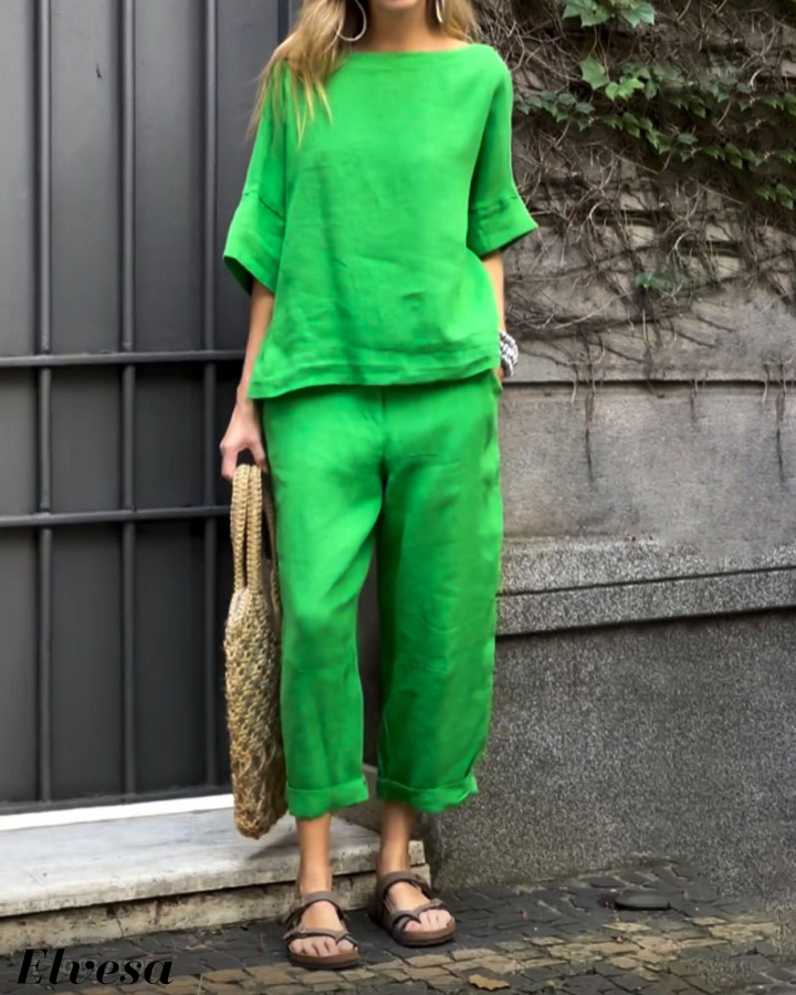 Front view, model wearing a bright green two piece set with a boat neck top and relaxed fit pants