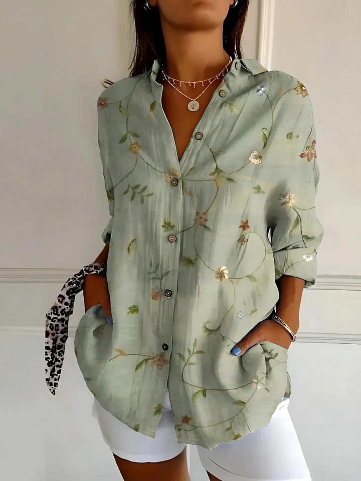 Sage green floral pattern blouse with a loose fit and white trousers