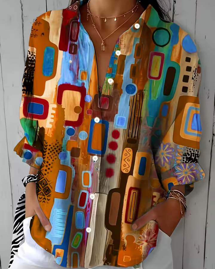 Elizabeth Chic Timeless Blouse, front view worn by model, with a vibrant abstract print, unbuttoned collar and rolled sleeves