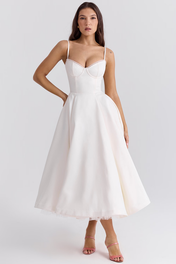 Front view worn by model, a white satin corset dress with delicate lace trim and a full midi skirt