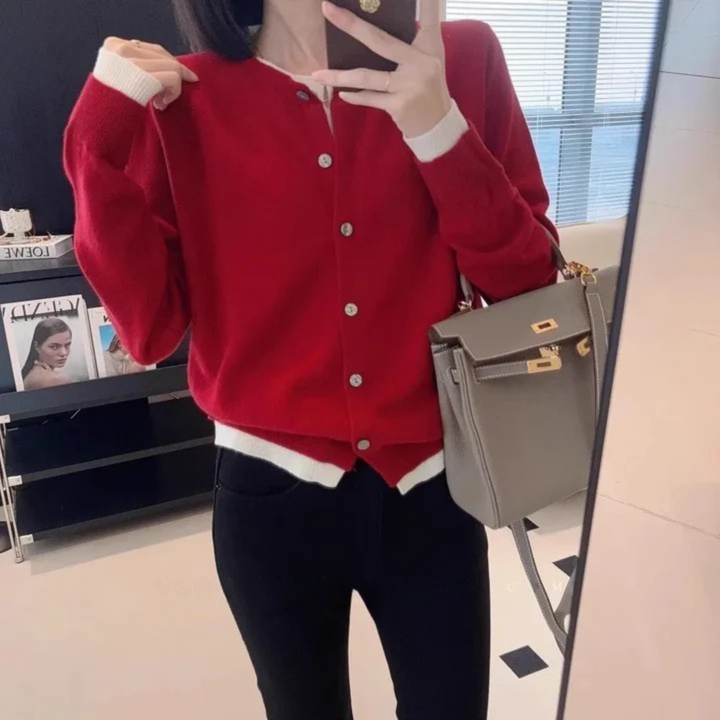 Front view worn by model, a red cashmere cardigan over a white top and black pants