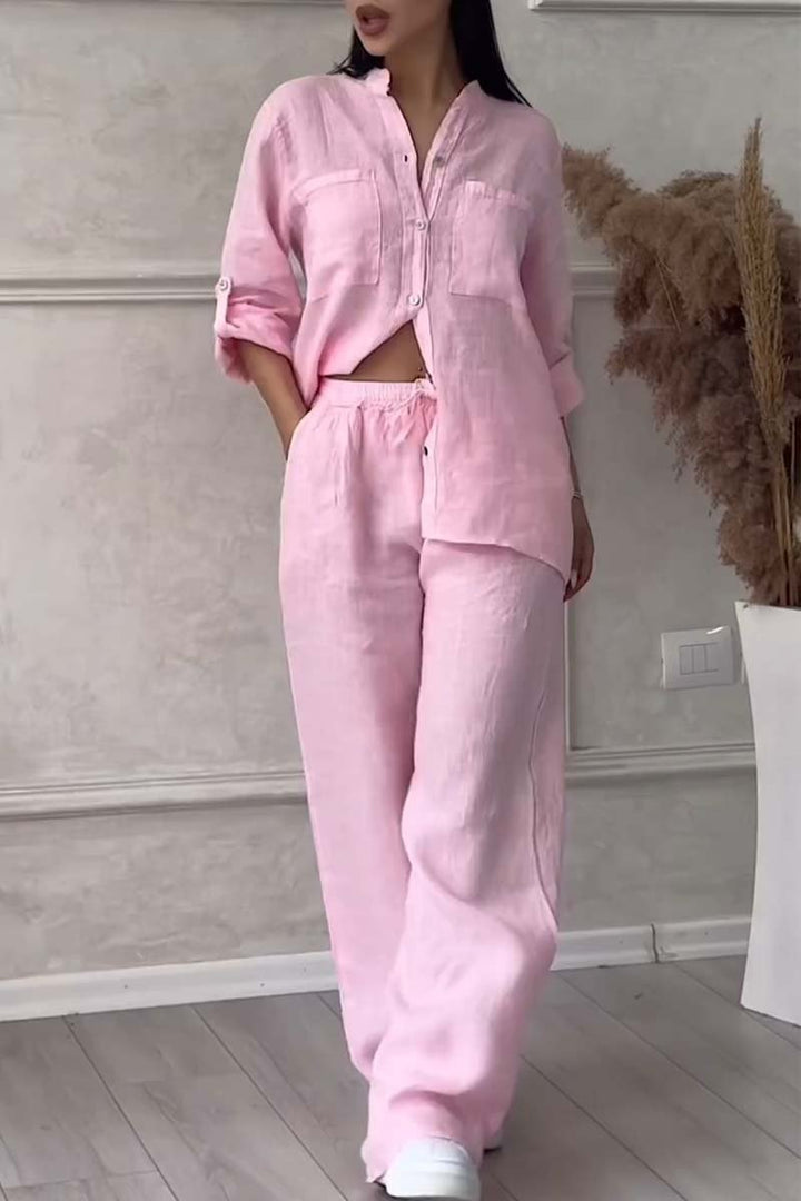 Front view of a model in a light pink long sleeve blouse and wide leg pants set