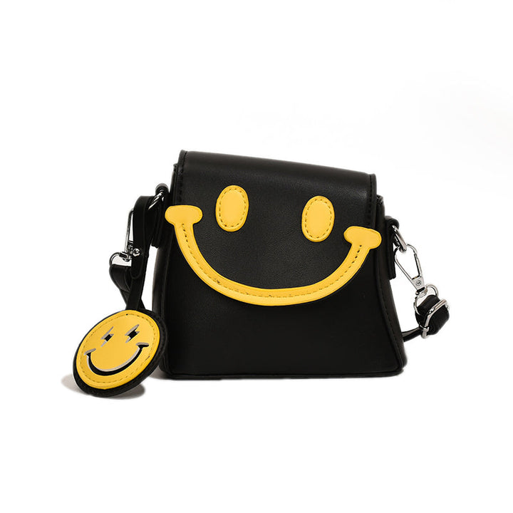 Front view of a black Bright Smile crossbody bag with yellow smiley face and keyring against a white background
