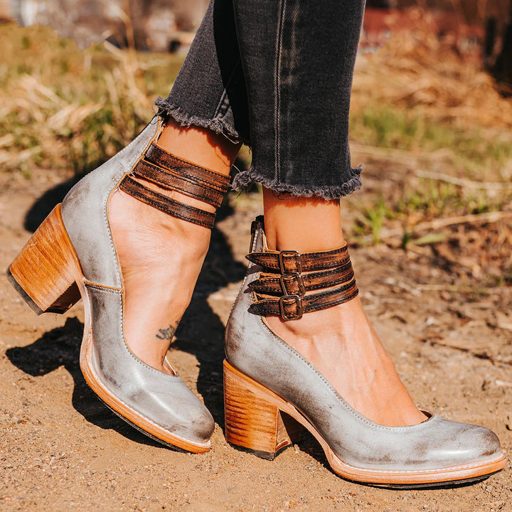 Worn by model, elegant vintage heeled sandals in grey with triple buckled ankle straps and block heels