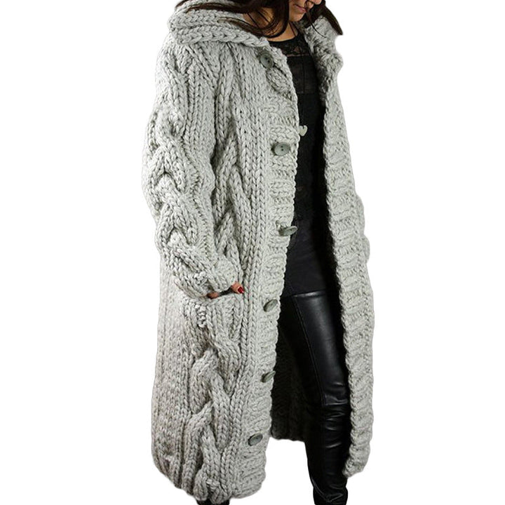 Three quarter view, model wearing a long light grey oversized wool blend cardigan with chunky cable knit and buttons
