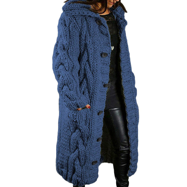 Front view, model wearing a long blue oversized wool blend cardigan with chunky cable knit, toggle and button closure