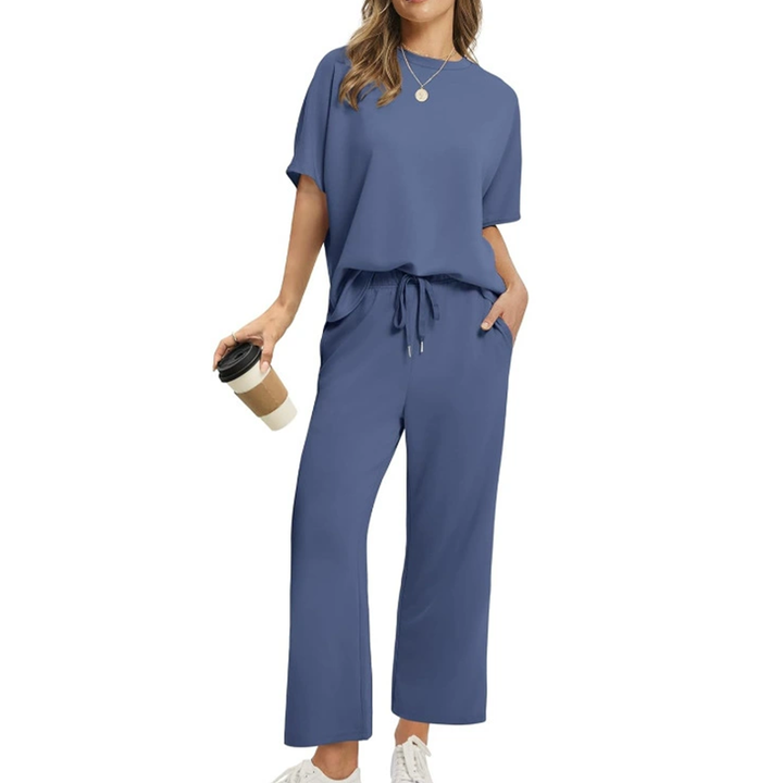 Front view, model wearing a comfortable two-piece casual top and pants set in blue with a coffee cup, cropped