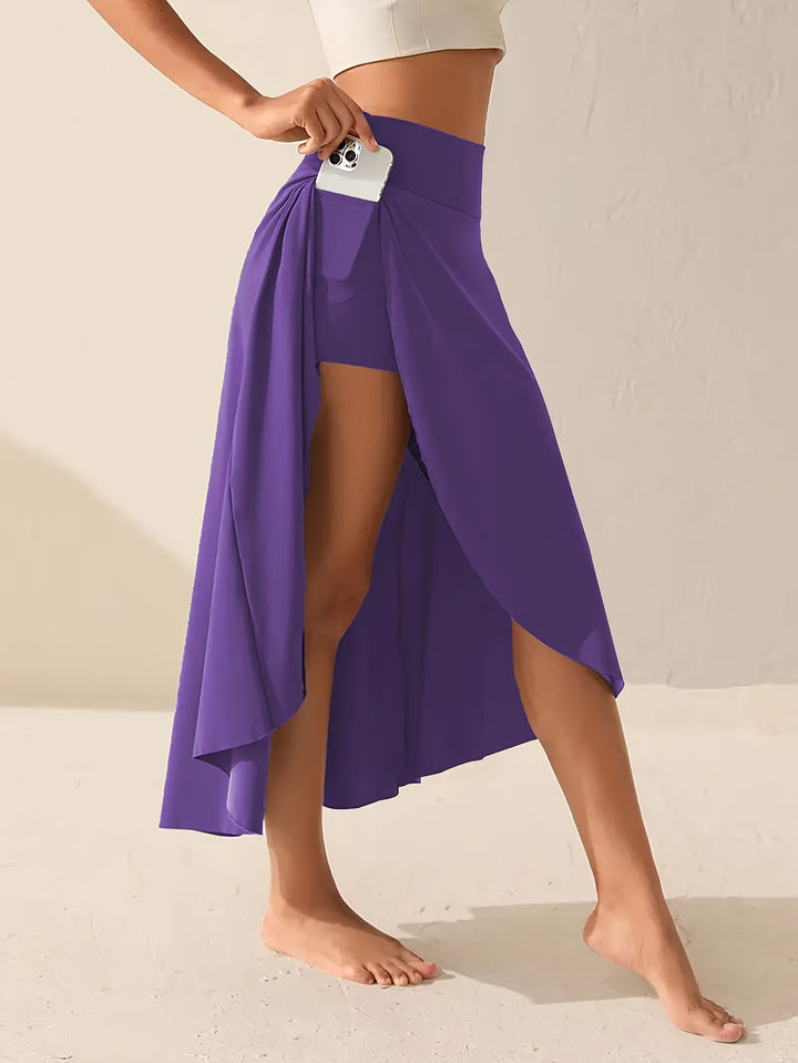 Close up, model inserting phone into pocket of plus-size asymmetric sports skirt