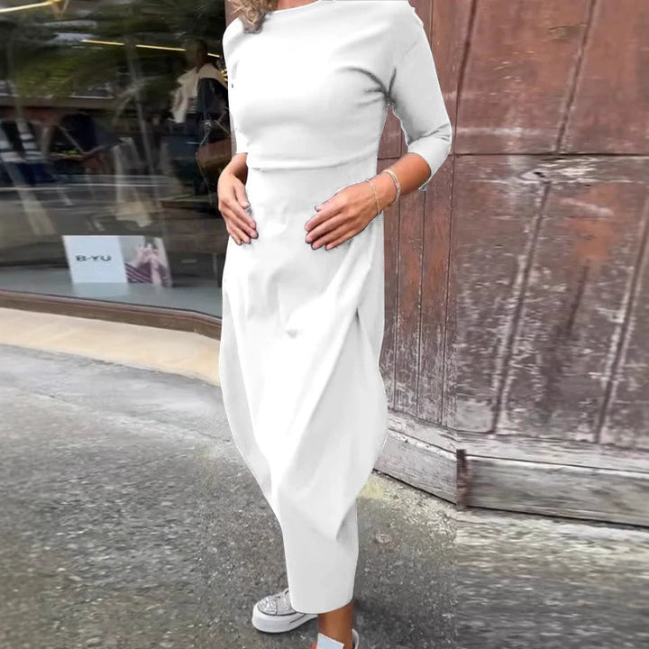 Side view of a model wearing the white Lana A-Line Dress with hands on her stomach and white sneakers