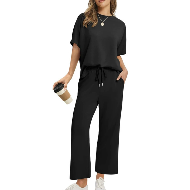 Front view, model wearing a comfortable two-piece casual top and pants set in black with a coffee cup