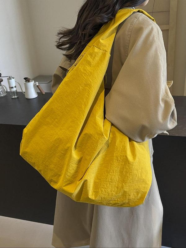 Back view, worn by model, of a yellow Lush Everyday Tote Bag over a beige jacket