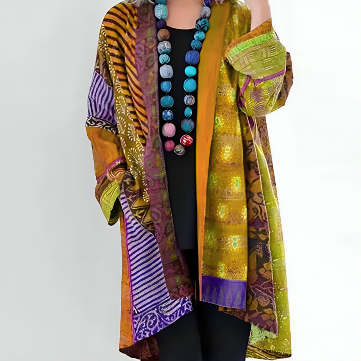 Elisa coat worn by model, front view, showing the colourful patterned fabric and bead necklace