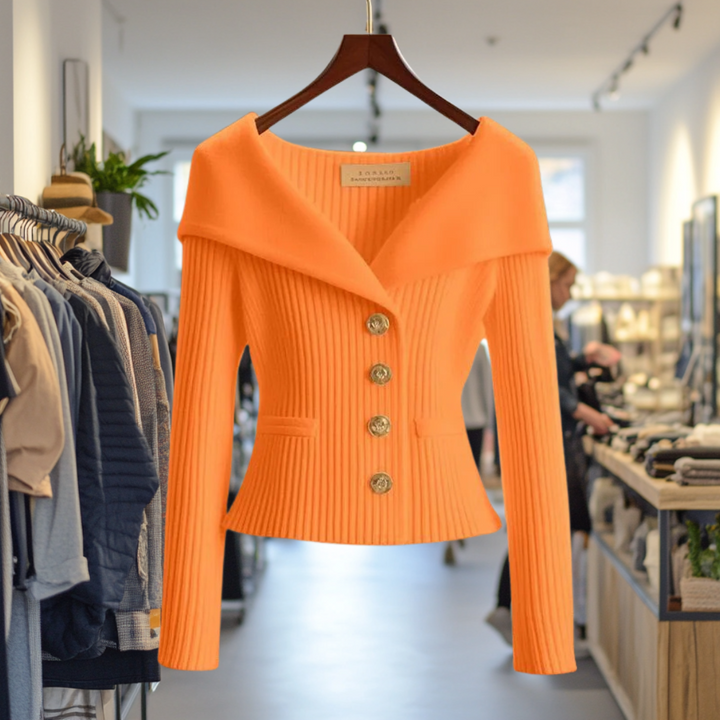 Front view of the orange Priscilla Cardigan in a boutique, highlighting the ribbed knit and gold buttons