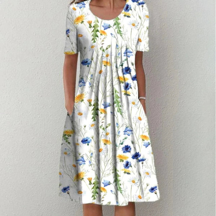 Three quarter front view of an elegant printed short-sleeved dress with a flared skirt and pockets, worn by model