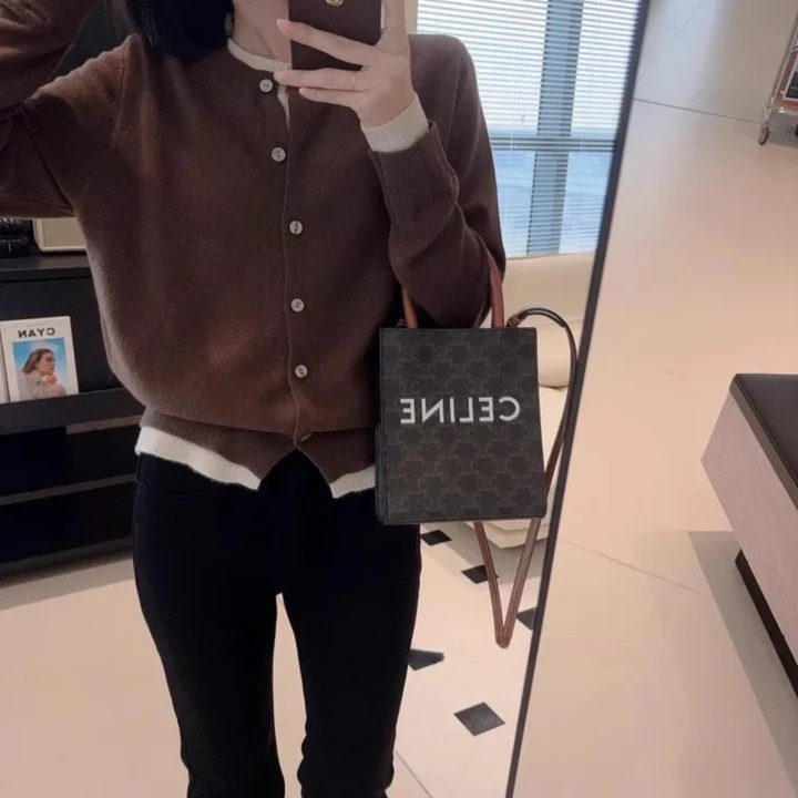 Front view worn by model, a brown cashmere cardigan over a white top and black pants with a handbag