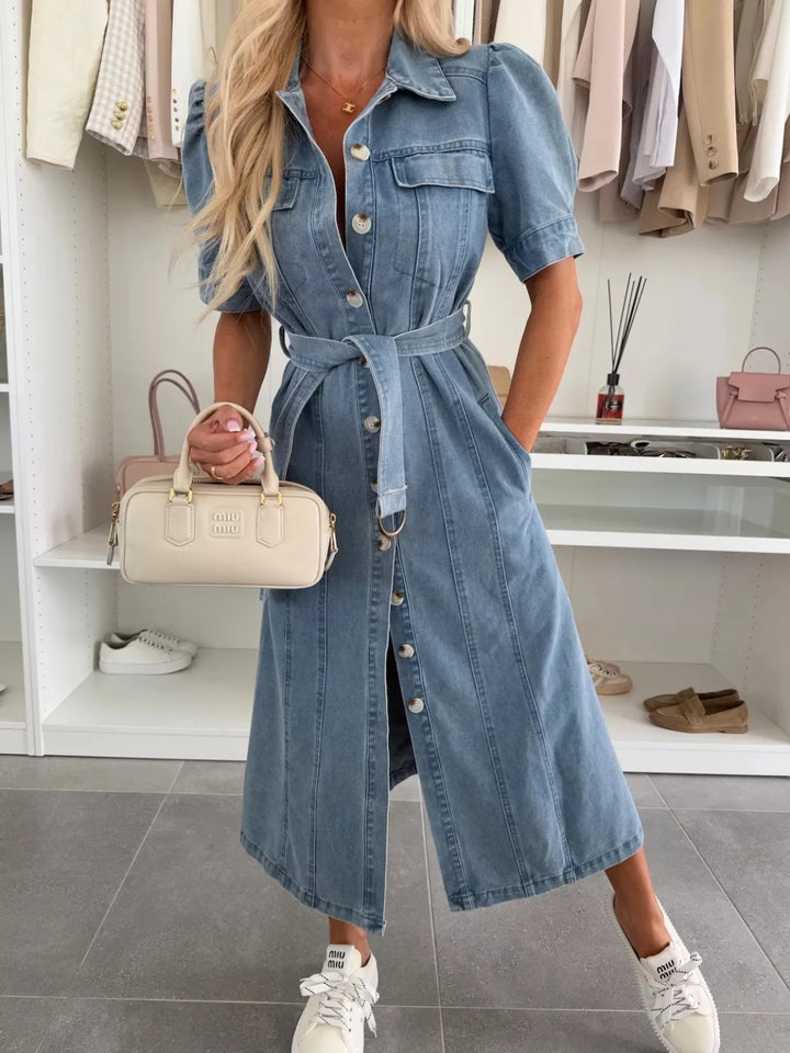 Front view of a model wearing the elegant lapel lace-up maxi denim dress with a white handbag and sneakers