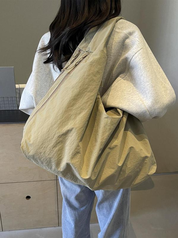Back view, worn by model, of a beige Lush Everyday Tote Bag over a light grey hoodie and blue jeans