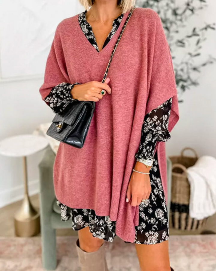 Front view of model wearing the Erica oversized V-neck poncho sweater in a dusty pink over a floral dress