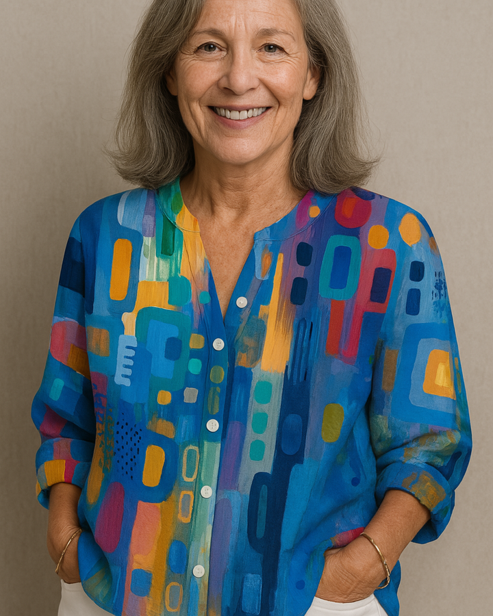 Elizabeth Chic Timeless Blouse, close up worn by model, with a vibrant abstract print and hands in pockets