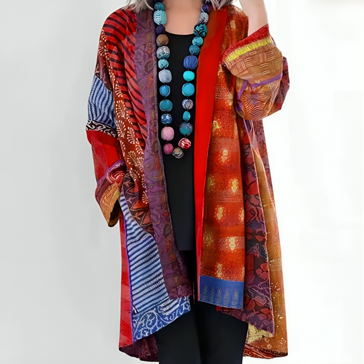 Elisa coat worn by model, close up front view, showing colourful patterned fabric and bead necklace