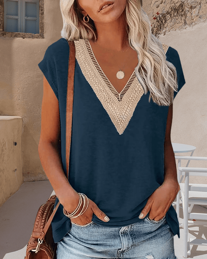 Front view, model wearing a navy V-neck lace t-shirt with light wash denim shorts and a brown shoulder bag