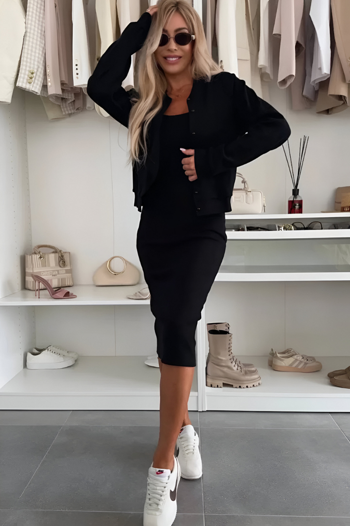 Front view of a woman in a black comfortable midi dress and cardigan set, smiling at the camera